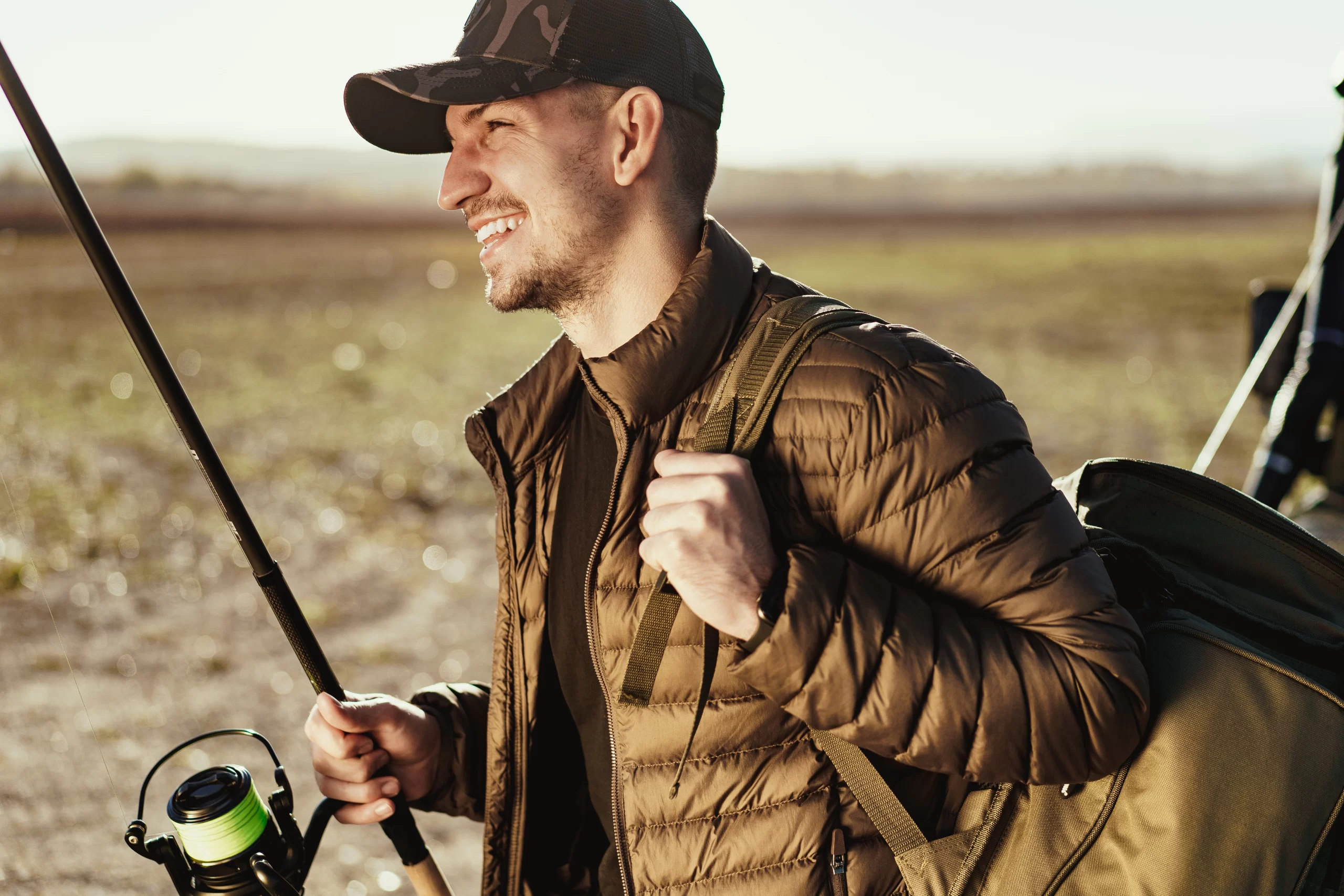 Portrait of a young male fisherman with fishing rod close up